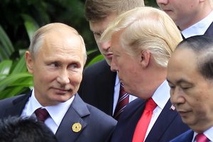 Russian President Vladimir Putin, left, and U.S. President Donald Trump talk as they arrive for the family photo session during the Asia-Pacific Economic Cooperation (APEC) Summit in Danang, Vietnam, Saturday, Nov. 11, 2017.