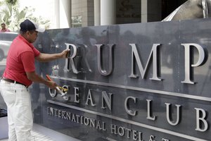 A man removes the word Trump, off a marquee outside the Trump Ocean Club International Hotel and Tower in Panama City, Monday, March 5, 2018.