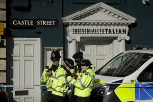 Police officers stand outside a Zizzi restaurant in Salisbury, England, Wednesday, March 7, 2018, near to where former Russian double agent Sergei Skripal was found critically ill.