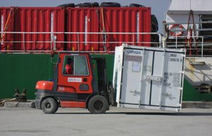 Unloading the supply ship Vestlandia operated by Royal Arctic Line at the port in Upernavik, Greenland. Small Toyota forklifts are used in the process. The container here contains explosives (according to the label).