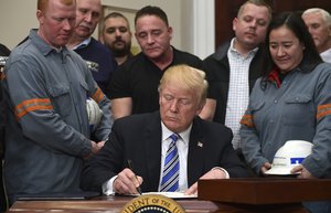 President Donald Trump signs a proclamation on steel imports during an event in the Roosevelt Room of the White House in Washington, Thursday, March 8, 2018.