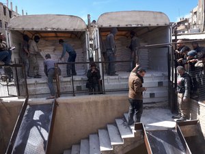 This photo released on Friday March 9, 2018 by the Syrian anti-government rebels Army of Islam, which has been authenticated based on its contents and other AP reporting, shows workers unload from trucks humanitarian aid, in Douma, eastern Ghouta, a suburb of Damascus, Syria.