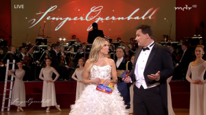 Orchester, Balletttänzerinnen im Hintergrund, im Vordergrund: Sylvie Meis im weißen Ballkleid und Guido Maria Kretschmer im Frack