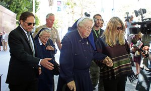 Sisters Catherine Rose Holzman, second left, and Rita Callanan, center, is escorted by businesswoman Dana Hollister, right, out of Los Angeles Superior Court on Thursday, July 30, 2015.