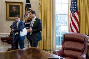 Treasury Secretary Steve Mnuchin's Chief of Staff Eli Miller, left, and White House aide John McEntee, right, stand in the Oval Office as President Donald Trump speaks at a tax reform meeting with American workers at the White House, Wednesday, Jan. 31, 2018, in Washington.