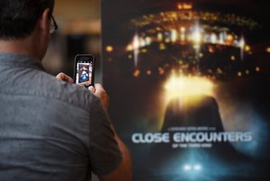 A filmgoer takes a picture of the poster for