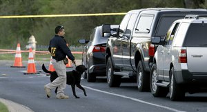 An ATF agent works with his dog near the site of Sunday's explosion, Monday, March 19, 2018, in Austin, Texas.