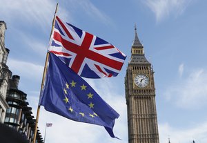 A European and a Union flag fly alongside Big Ben during an Anti Brexit campaigners march in Parliament in London, Saturday March 25, 2017.