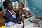 In this Friday, Oct. 30, 2009 picture a caretaker looks after a baby girl in the Siaya hospital in Western Kenya. The girl was found abandoned in the street and suffering with malaria. A new vaccine being tested at the hospital is giving the medical community hope that for the first time it will soon be able to reduce by half the number of African children killed by the mosquito-borne disease every year.