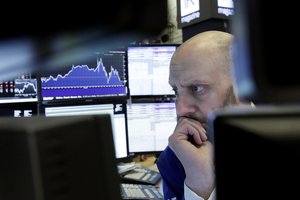 Trader Meric Greenbaum is framed by his monitors as he works on the floor of the New York Stock Exchange