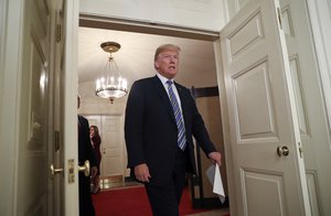 In this March 23, 2018, photo, President Donald Trump walks into the Diplomatic Room of the White House in Washington, to speak about the $1.3 trillion spending bill.