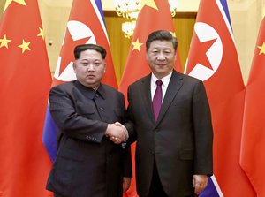 In this photo provided Wednesday, March 28, 2018, by China's Xinhua News Agency,  North Korean leader Kim Jong Un, left, and Chinese President Xi Jinping shake hands in Beijing, China.