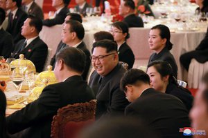 In this March 26, 2018, photo provided March 28, 2018 by the North Korean government, North Korean leader Kim Jong Un, center, smiles as he and Chinese counterpart Xi Jingping, center left, attend a banquet at the Great Hall of the People, in Beijing.