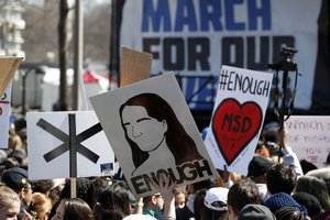 People hold signs during the "March for Our Lives" rally in support of gun control, Saturday, March 24, 2018, in Washington.