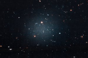 This large, fuzzy-looking galaxy is so diffuse that astronomers call it a “see-through” galaxy because they can clearly see distant galaxies behind it.