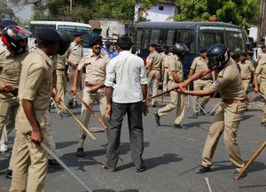 India’s lower caste Dalit man stands as policemen beat him during a nationwide strike in Ahmadabad, India, Monday, April 2, 2018.