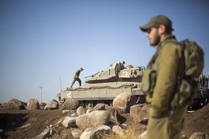 Israeli soldiers gather next to their tanks near the border with Syria in the Israeli-controlled Golan Heights, Monday, Nov. 28, 2016.