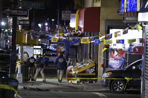 Investigators look over the scene where officers shot and killed a man in the Crown Heights section of Brooklyn on Wednesday, April 4, 2018 in Brooklyn, New York.