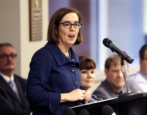 In this Feb. 2, 2018 file photo, Oregon Gov. Kate Brown speaks in Portland, Ore. Brown appeared before the Oregon Senate Judiciary Committee on Tuesday, Feb. 20, 2018, to support a bill that would expand a ban on the purchase or possession of firearms by people convicted of stalking and domestic violence or with restraining orders.