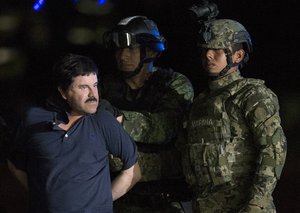 Mexican drug lord Joaquin "El Chapo" Guzman is escorted by army soldiers to a waiting helicopter, at a federal hangar in Mexico City, Friday, Jan. 8, 2016.