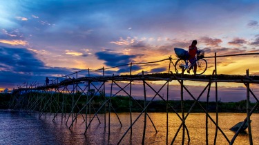 The old bamboo bridges are slowly disappearing from the Vietnam landscape.  Just outside of Hoi An, walking across this ...