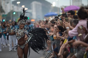 A member of a samba school parades along Copacabana Beach in Rio de Janeiro, Brazil. Musicians and members from Rio de ...