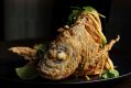 Dramatic free-standing whole deep-fried fish with green mango and sweet chilli.