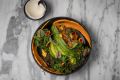 A plant bowl with quinoa, black lentil, pumpkin and preserved lemon tahini.