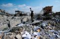 A Syrian soldier films the damage of a site which was attacked by US, British and French military strikes.