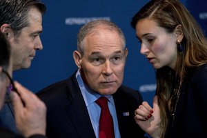 Environmental Protection Agency Administrator Scott Pruitt speaks with an aide during a news conference at the Environmental Protection Agency in Washington, Tuesday, April 3, 2018, on his decision to scrap Obama administration fuel standards.