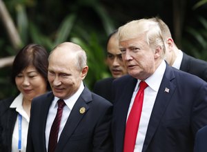 U.S. President Donald Trump, right, and Russia's President Vladimir Putin, center, talk during the family photo session at the APEC Summit in Danang, Saturday, Nov. 11, 2017.