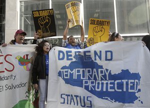 Supporters of temporary protected status immigrants hold signs and cheer at a rally before a news conference announcing a lawsuit against the Trump administration over its decision to end a program that lets immigrants live and work legally in the United States outside of a federal courthouse in San Francisco, Monday, March 12, 2018.