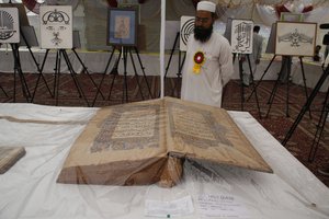 A Kashmiri man looks at oversized centuries old Quranic manuscripts at an exhibition at Jammu and Kashmir Academy of Art, Culture and Languages on August 14, 2012 in Srinagar, the summer capital of Indian Administered Kashmir, Indian. On Tuesday Jammu and Kashmir Academy of Art, Culture and Languages, in association with department of archives archeology and museum department of libraries and research, organized an exhibition of centuries old priceless documents, Quranic Manuscripts and calligraphy specimens.