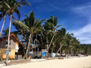 Kite surfing schools and rental services line up the beach front in Balabag Beach, Boracay island. Taken on May 2017.