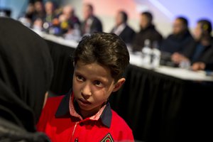 Eleven-year-old Syrian Hasan Diab who spoke and who's image was projected on a screen during a press conference talks to his mother in The Hague, Netherlands, Thursday, April 26, 2018.