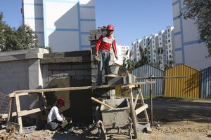 This Oct. 11, 2009 photo shows Chinese workers building a wall at a housing project funded by the Algerian government and built by a state-owned Chinese firm near Algiers, Algeria.