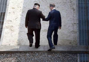 North Korean leader Kim Jong Un, left, and South Korean President Moon Jae-in cross the border line at the border village of Panmunjom in Demilitarized Zone Friday, April 27, 2018.