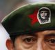 A woman, wearing a red star star military beret adorned with a patch depicting revolutionary icon Ernesto "Che" Guevara, ...