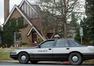 File - A police officer sits in her cruiser on Friday, Jan. 3, 1997, outside the home in which 6-year-old JonBenet Ramsey was found murdered in Boulder, Colorado on Dec. 26, 1996.