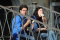 Tourists eat ice creams, sitting on a bridge in Venice.