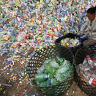 A worker separates plastic bottles at a recycling depot in Beijing.