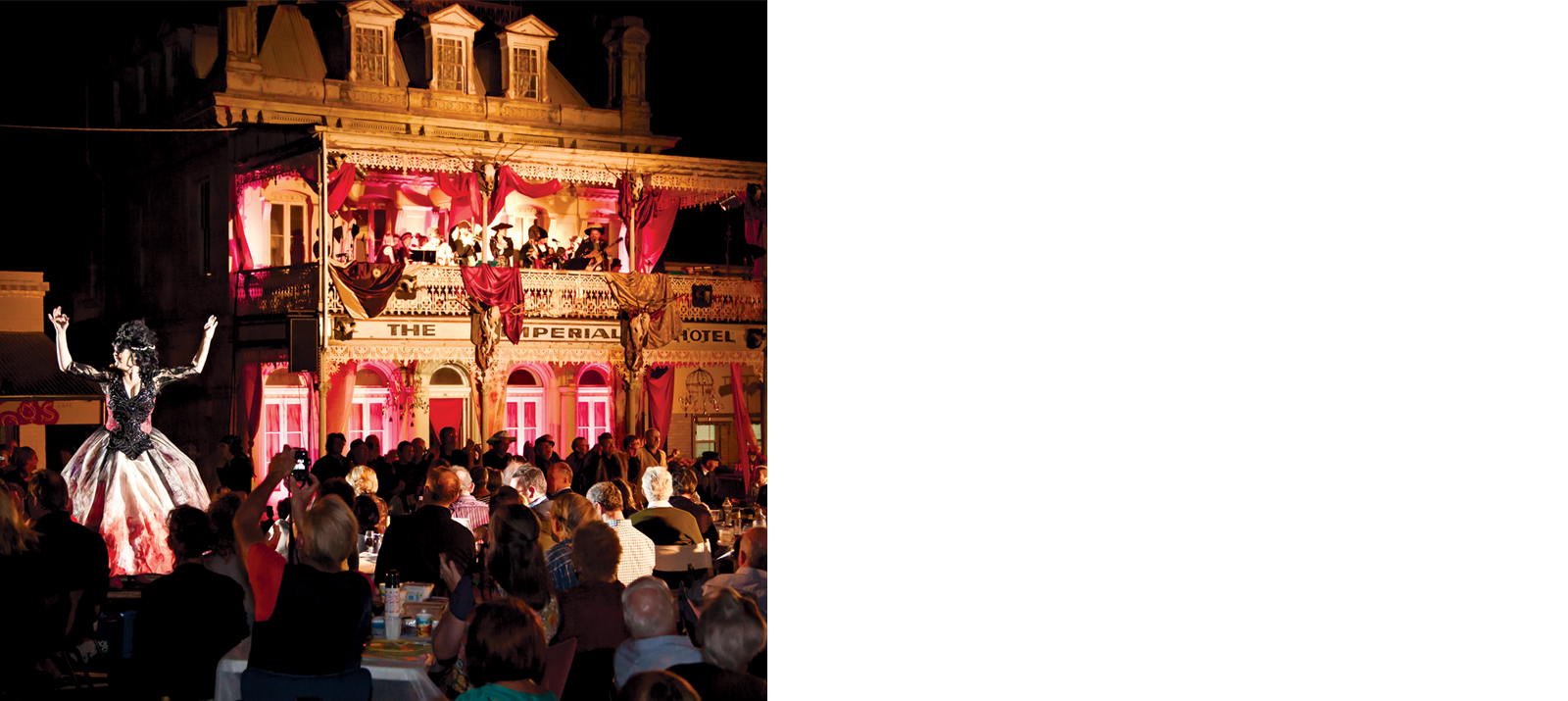 People watching a performer in a big dress with an old timey looking building in the background