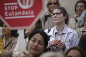 In this May 24, 2018 file photo, people stand on the steps of the Portuguese parliament in Lisbon during a protest against euthanasia. After legalizing abortion and same-sex marriage in recent times, Portuguese lawmakers will decide Tuesday, May 29, 2018