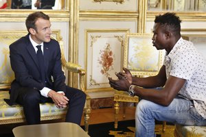 French President Emmanuel Macron, left, meets with Mamoudou Gassama, 22, from Mali, at the presidential Elysee Palace in Paris, Monday, May, 28, 2018.