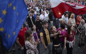 Opposition supporters shout slogans and wave Polish and European Union flags as they protest in front of the Supreme Court against a law on court control in Warsaw, Poland, Friday, July 21, 2017.