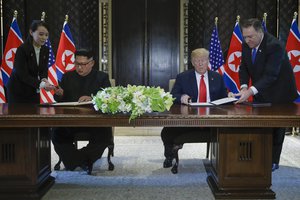 North Korea leader Kim Jong Un and U.S. President Donald Trump prepare to sign a document at the Capella resort on Sentosa Island Tuesday, June 12, 2018 in Singapore.