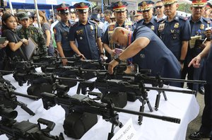 Philippine National Police Chief Director Gen. Ronald Dela Rosa, right, inspects a machine gun during blessing rites of newly procured equipment at Camp Bagong Diwa, in metropolitan Manila, Philippines, Thursday, Feb. 1, 2018.