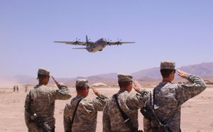 An Australian C130 takes off carrying the bodies of two Australian soldiers who were killed by an improvised explosive device in southern Afghanistan as members of the US Army 101st Aviation Group salute during take off in Tarin Kowt, Afghanistan on Wednesday, June 9, 2010.