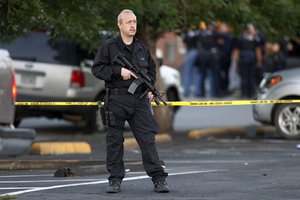 A SWAT team officer stands watch near an apartment house where the suspect in a shooting at a movie theatre lived in Aurora, Colo., Friday, July 20, 2012.