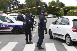 French police officers work at the crime scene the day after a knife-wielding attacker stabbed a senior police officer to death Monday evening outside his home in Magnanville, west of Paris, France, Tuesday, June 14, 2016.